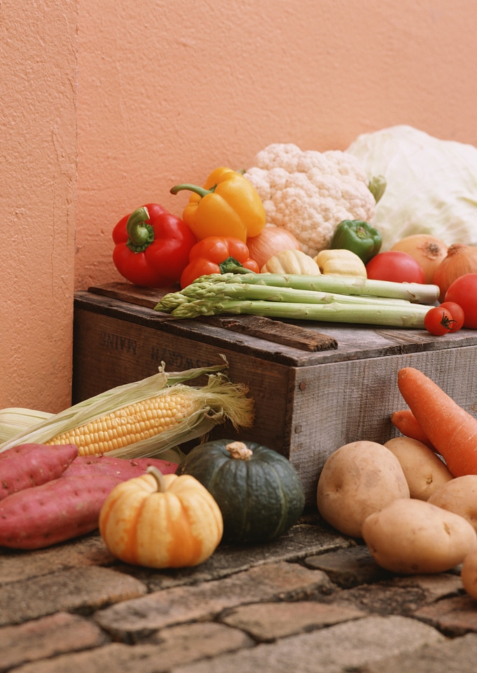 Wooden box in fresh vegetables on kitchen floor