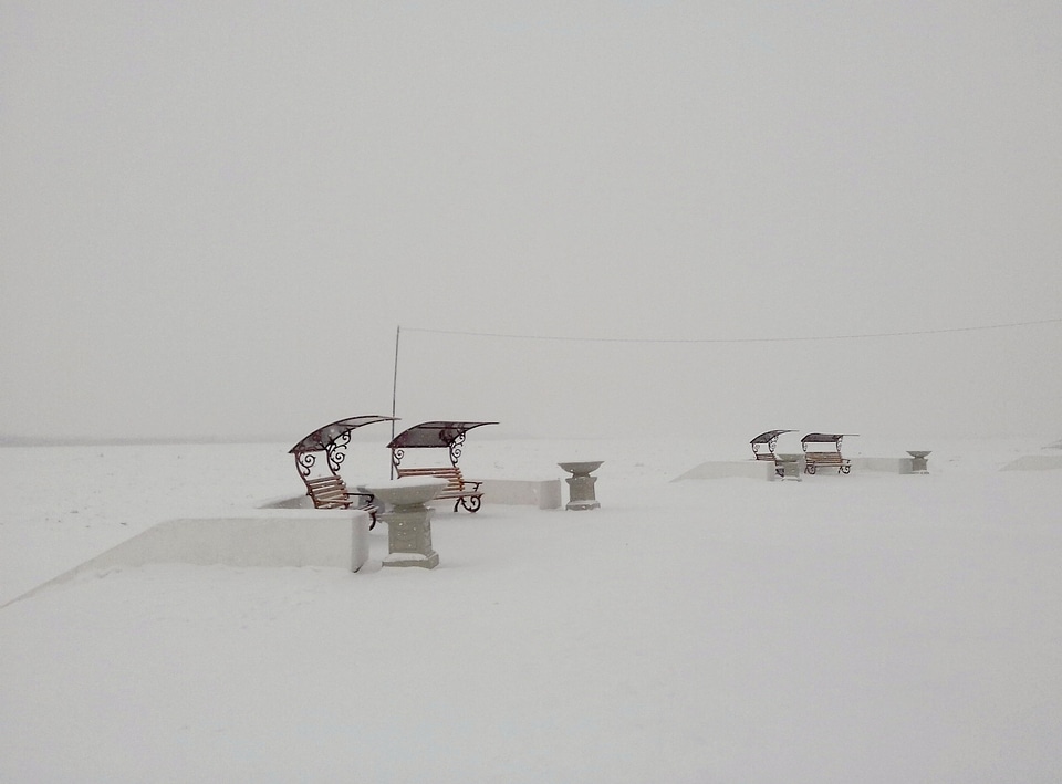 Two Black Metal Chairs covered in Snow