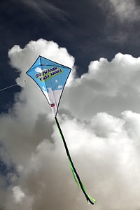 A blue kite flying against a blue sky