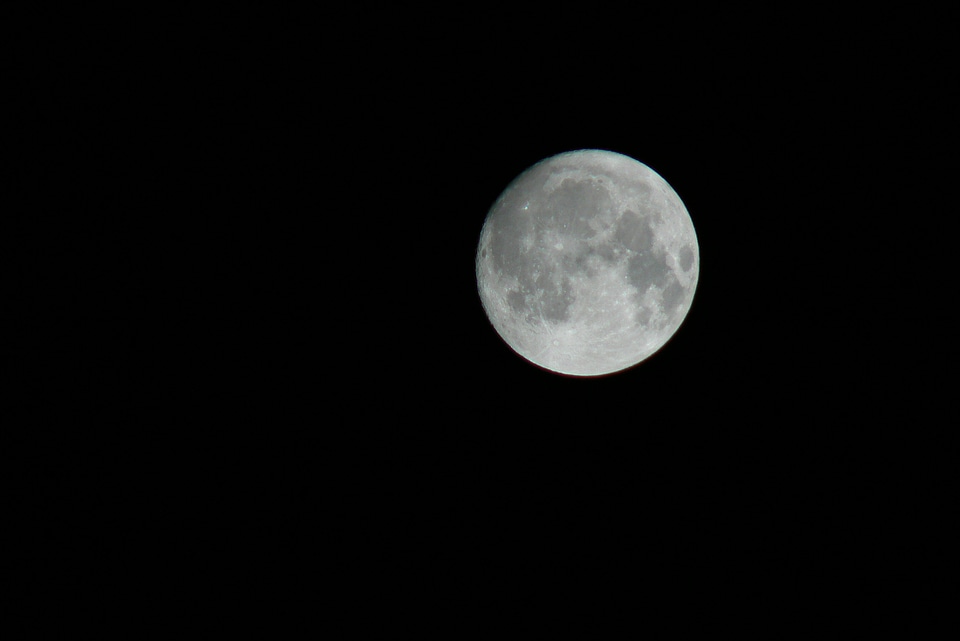 Full moon over dark black sky at night