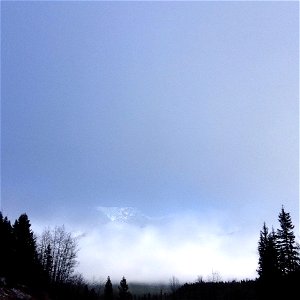 Mountain peeking through the clouds photo