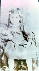 Studio portrait of a young girl seated on a chair, [n.d.] photo