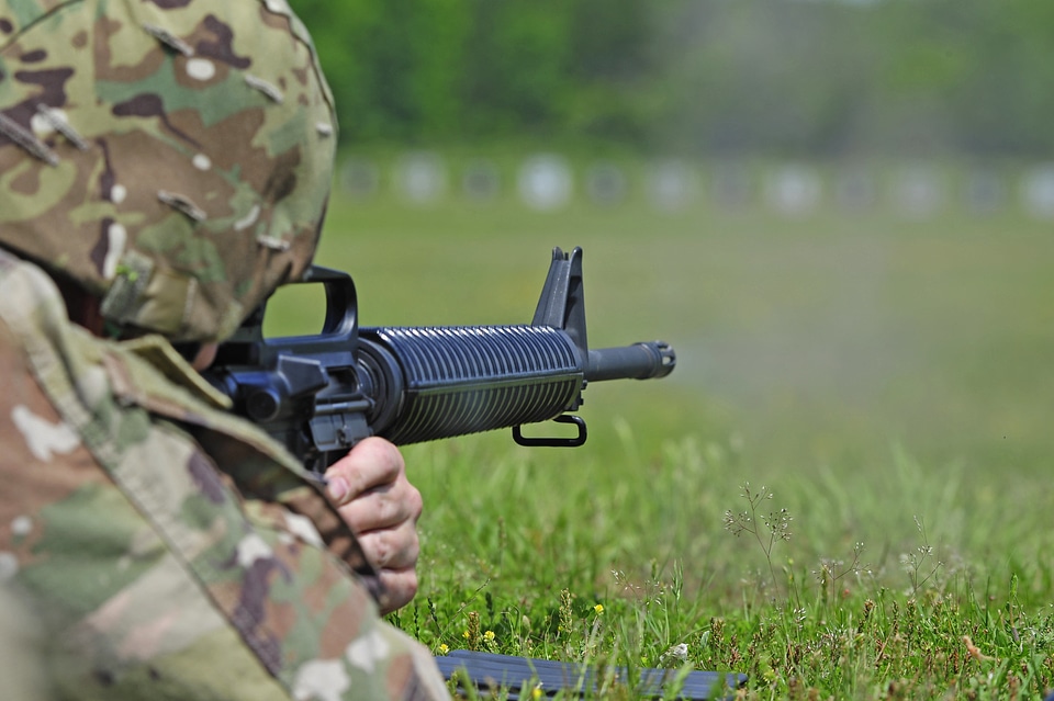 soldier aiming machine gun at firing range.