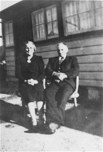 Couple seated outside a house photo