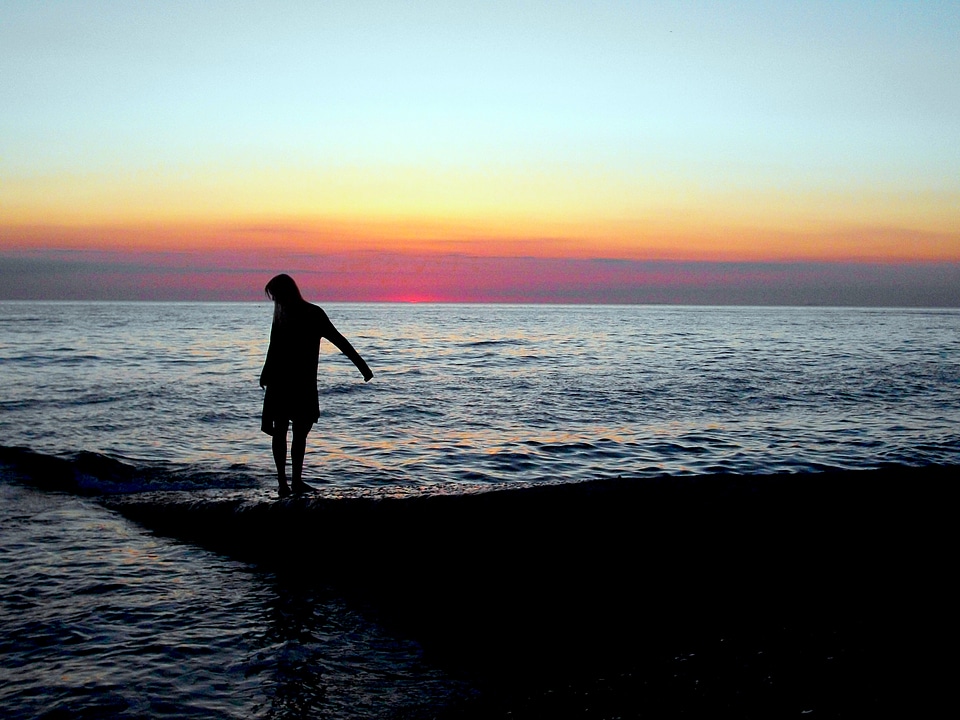 Young woman in summer dress standing on a rock