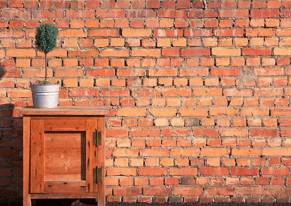 Can flower pot with green plant on table brick wall background