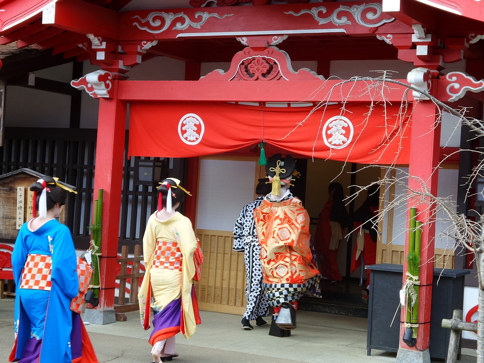 Three geishas walking on a street