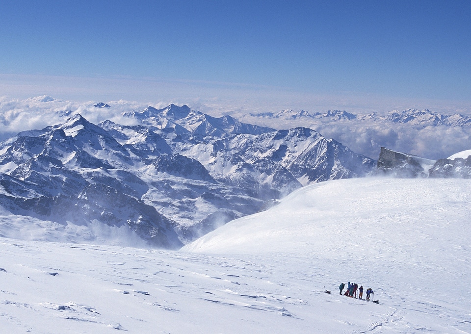 Group of skiers walks up the hill