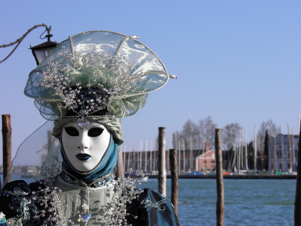 Costumed people in Venetian mask on during Venice Carnival
