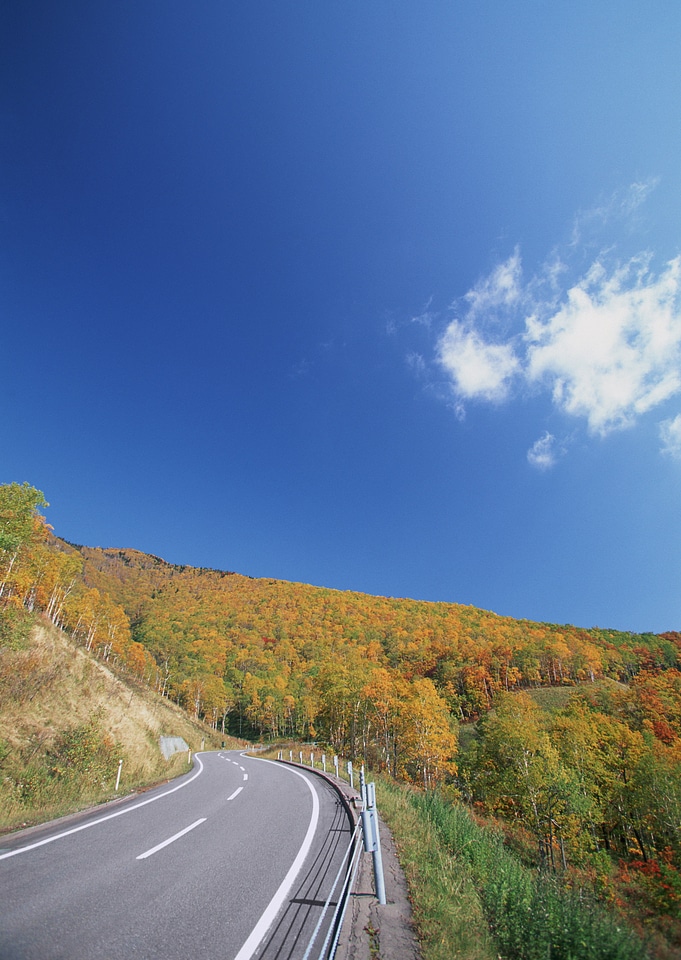 Turning mountain highway with blue sky and sea