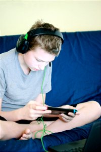 Teen Child Playing Electronic Handheld Video Game Device photo