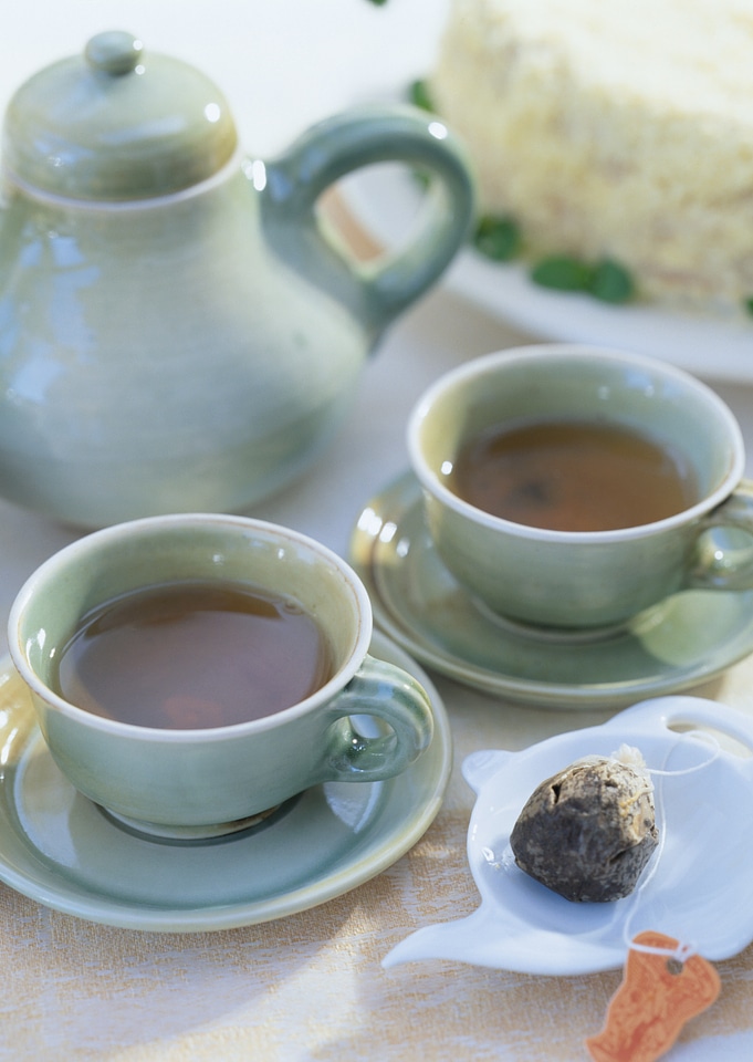 Clay teapot tea flow in cup