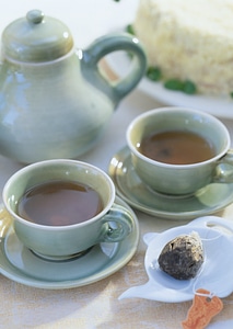 Clay teapot tea flow in cup photo