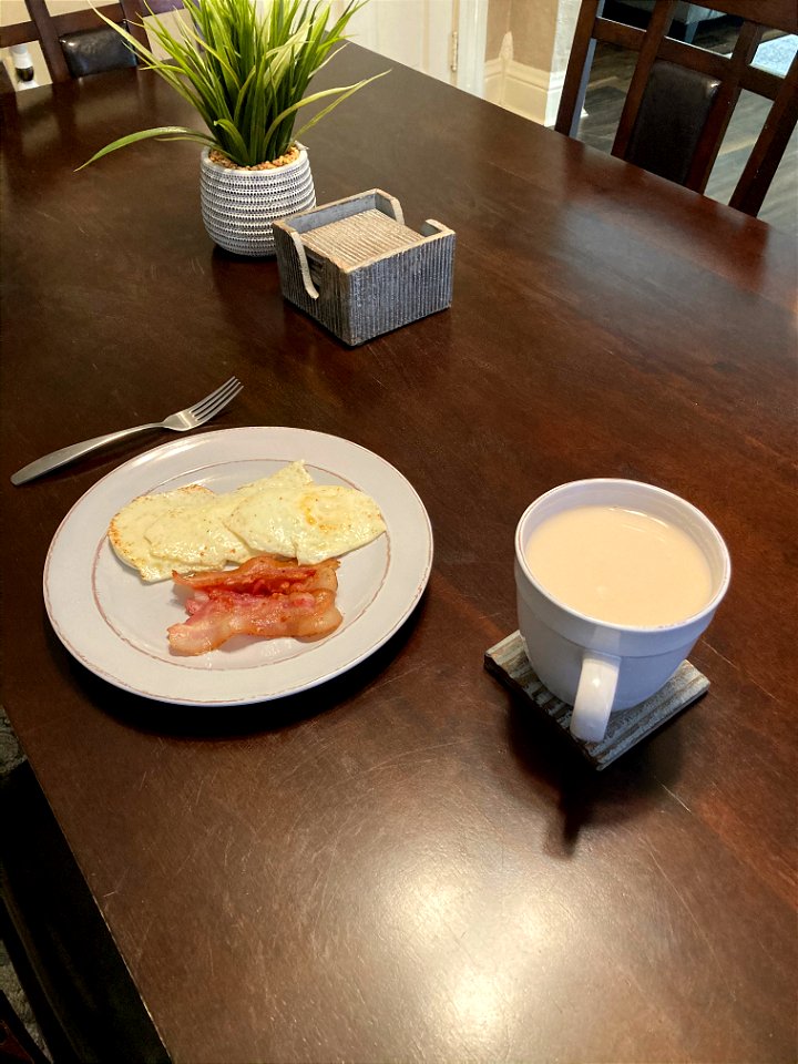 A breakfast of eggs, bacon, and tea