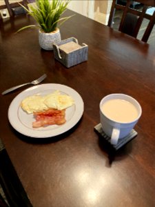 A breakfast of eggs, bacon, and tea
