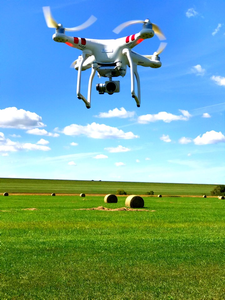 Look at that DJI Phantom 3 suspended in Blue Sky above Green Grass & Hay Bales in Lawrence, Kansas