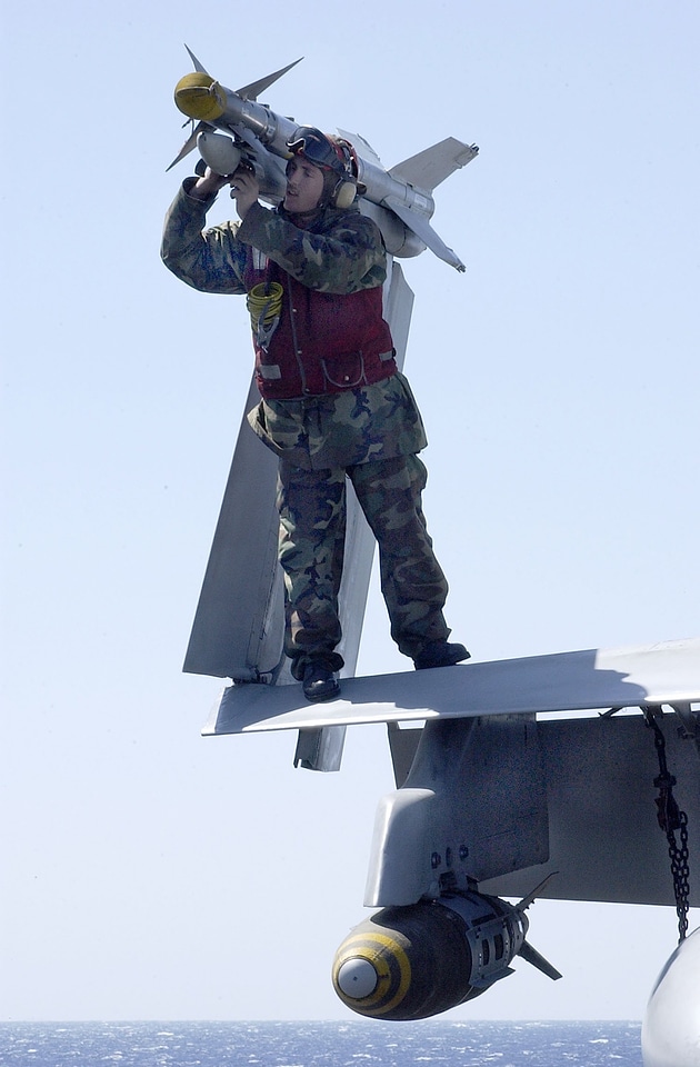 An Aviation Ordnanceman disarms an AIM-9 Sidewinder missile