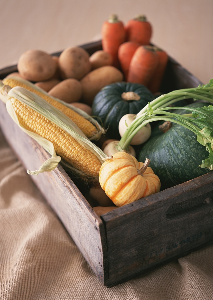 Assorted vegetables in wooden box background
