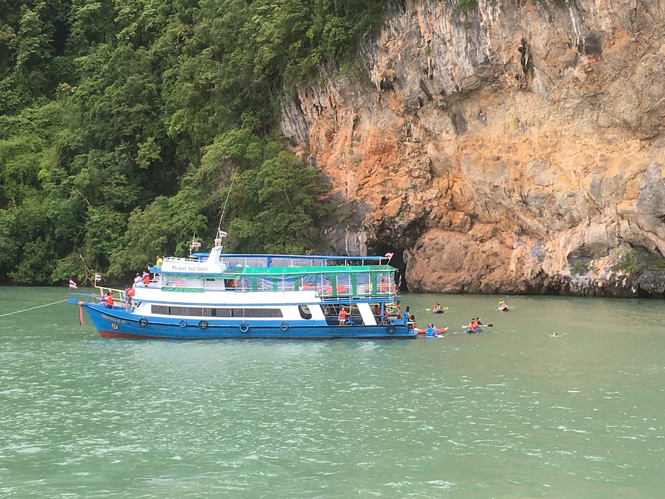 Tourists kayaking through limestone cliffs in Phang-nga Bay