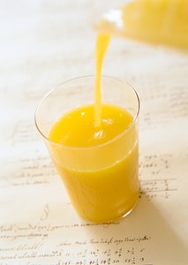 Orange juice pouring into glass photo