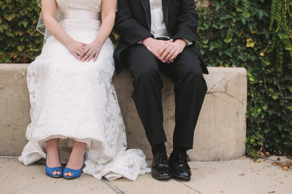 the bride and groom sit on a bench