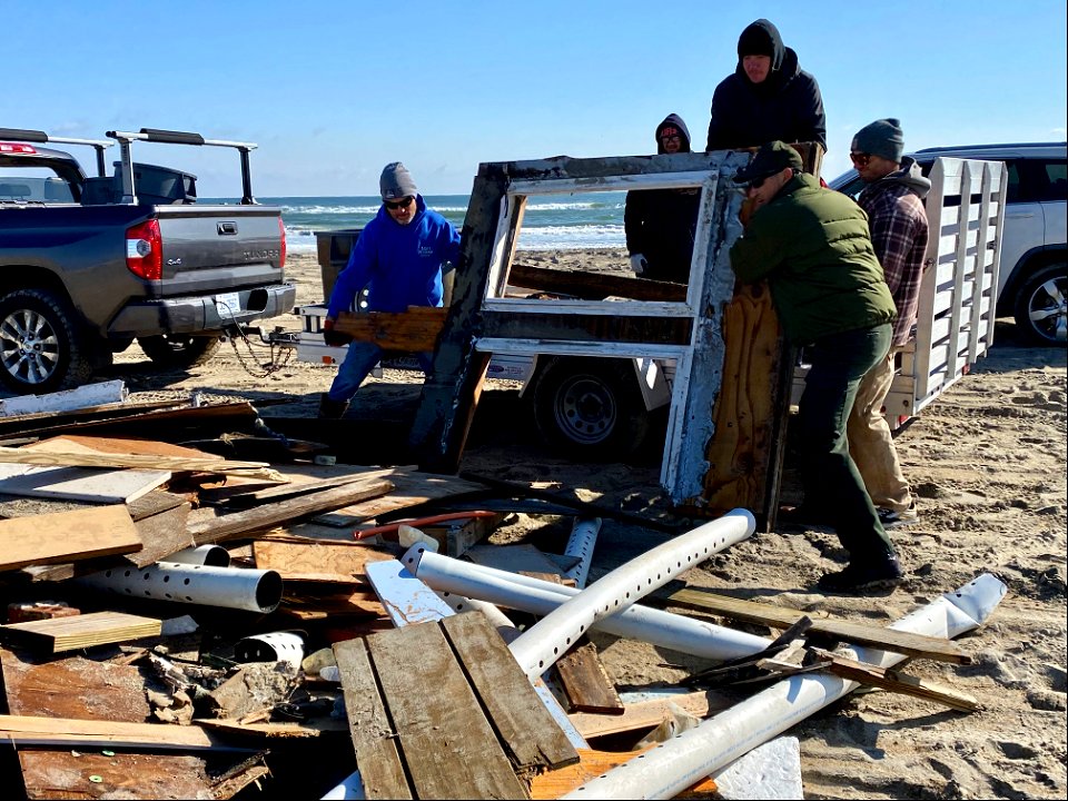 Volunteers and Superintendent Hallac unload debris from trailer 02-14-2022