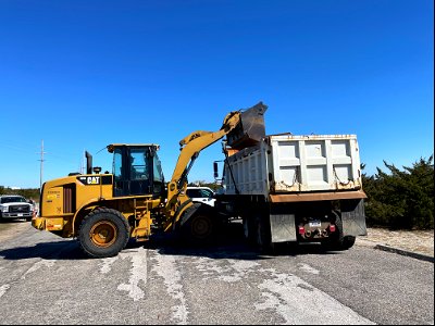 Front-end loader empties debris into dump truck. photo