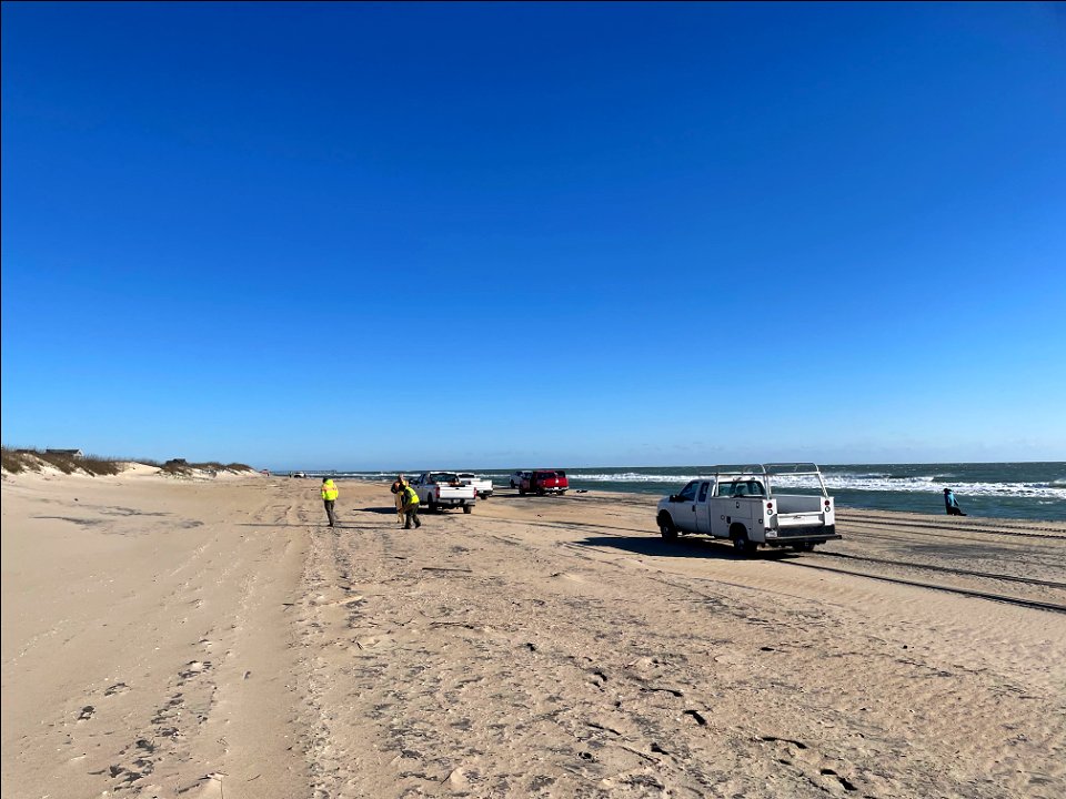 National Park Service employees collect debris on the beach.