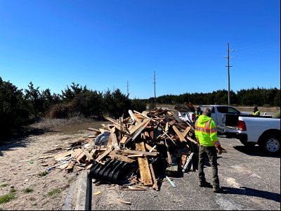 Staff work to transfer debris from truck to collection site