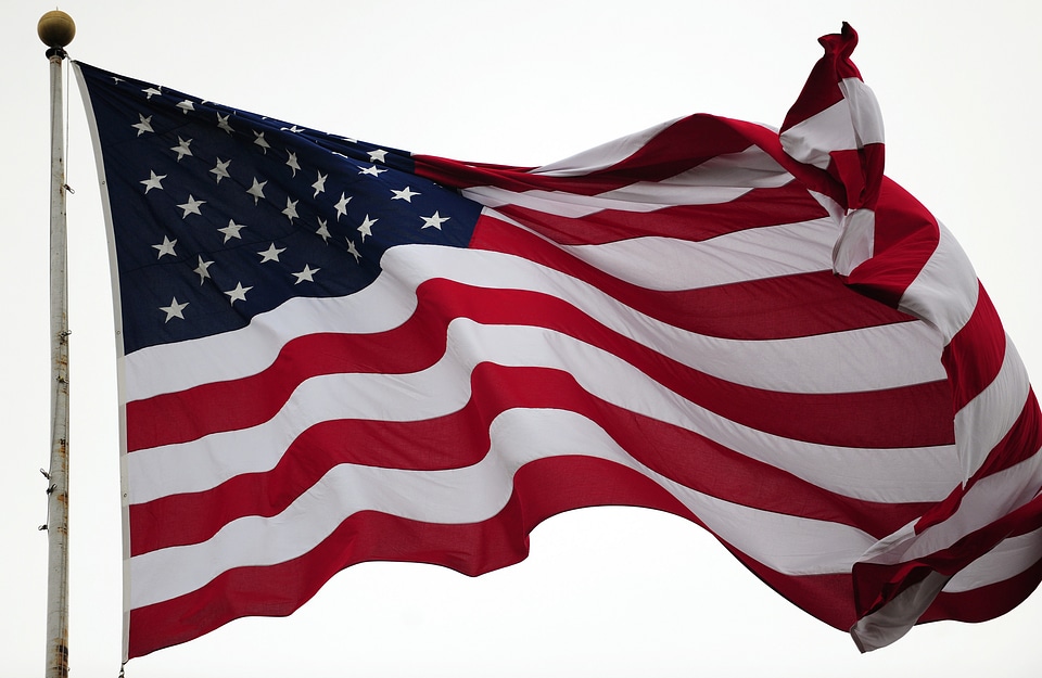 a waving USA flag. Blue sky background