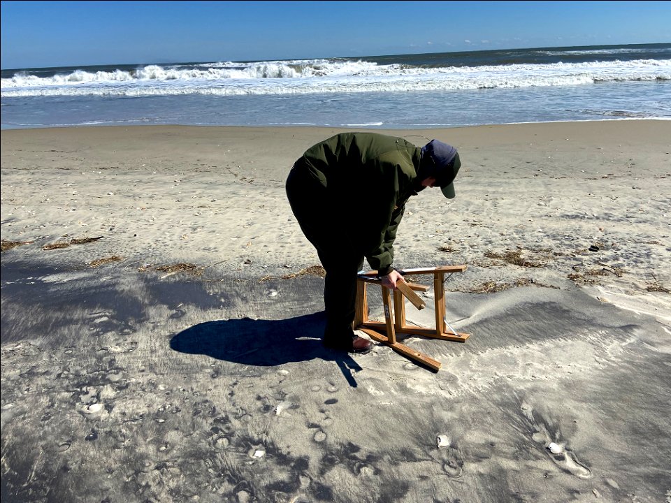 National Park Service employee picks up house debris. photo