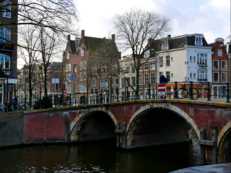 Old brick bridge with three arches over the canal water of the Prinsegracht in Amsterdam old city; free photo, Fons Heijnsbroek photo