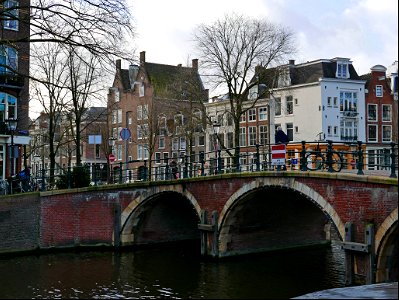 Old brick bridge with three arches over the canal water of the Prinsegracht in Amsterdam old city; free photo, Fons Heijnsbroek photo