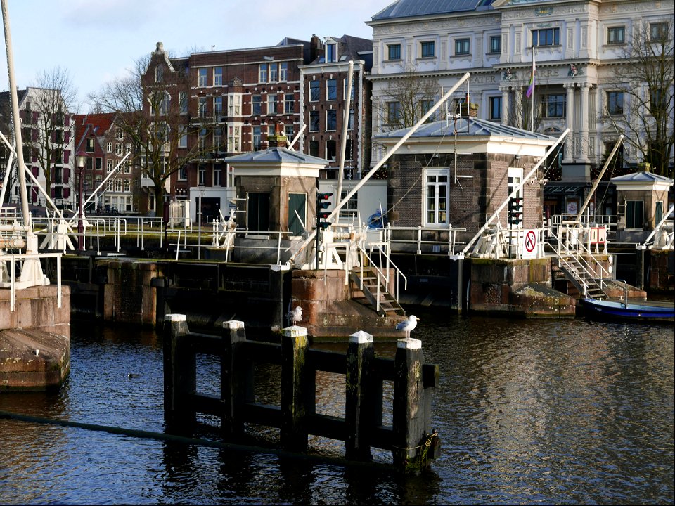 Close-up view of old water locks in the river Amstel , Amsterdam city; free urban photo by Fons Heijnsbroek, 2022.