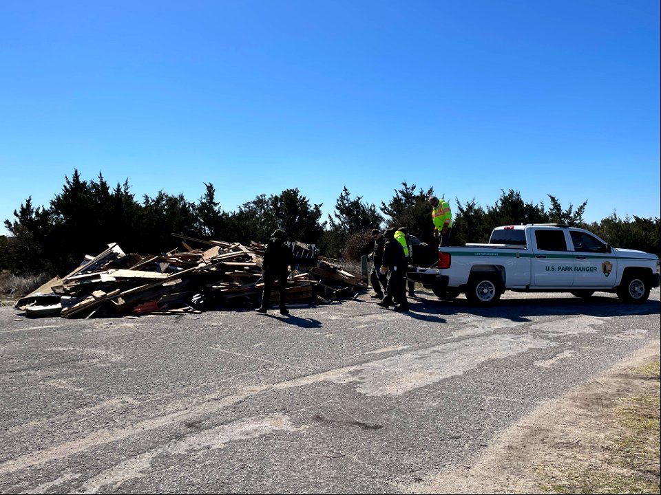 National Park Service employees work to transfer debris from truck to debris staging pile photo