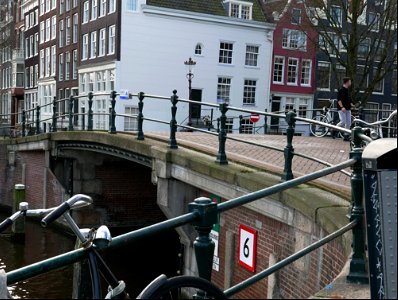 Old brick bridge in Amsterdam city, over canal Prinsengracht; free urban photo by Fons Heijnsbroek, 2022. photo