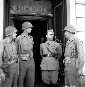 SC 184872 - L-R: Colonel R. Kilroe, N.Y.; Major Thomas Lancer, N.Y.; Saltala Macchia Guiseppe, Political Security Officer, Fascist Party, and Capt. Ray Regan, have a discussion after American entry to establish U.S. Military control of the city.
