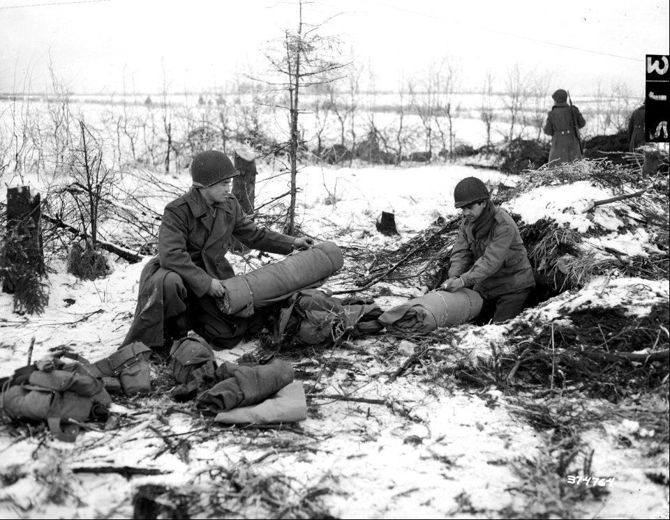 SC 374764 - Pfc. John Jaciow, Ludlow, Mass., left, and Pfc. Nicholas Guillen, El Paso, Texas, right, move into front lines. Belgium, 2 January, 1945.