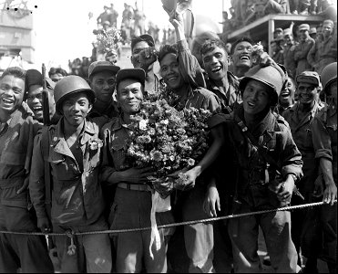 SC 34886 - Men of the first Philippines combat troops to reach Korea disembark from their transport at Pusan, and are presented with a bouquet of flowers by South Koreans greeting them. 19 September, 1950. photo