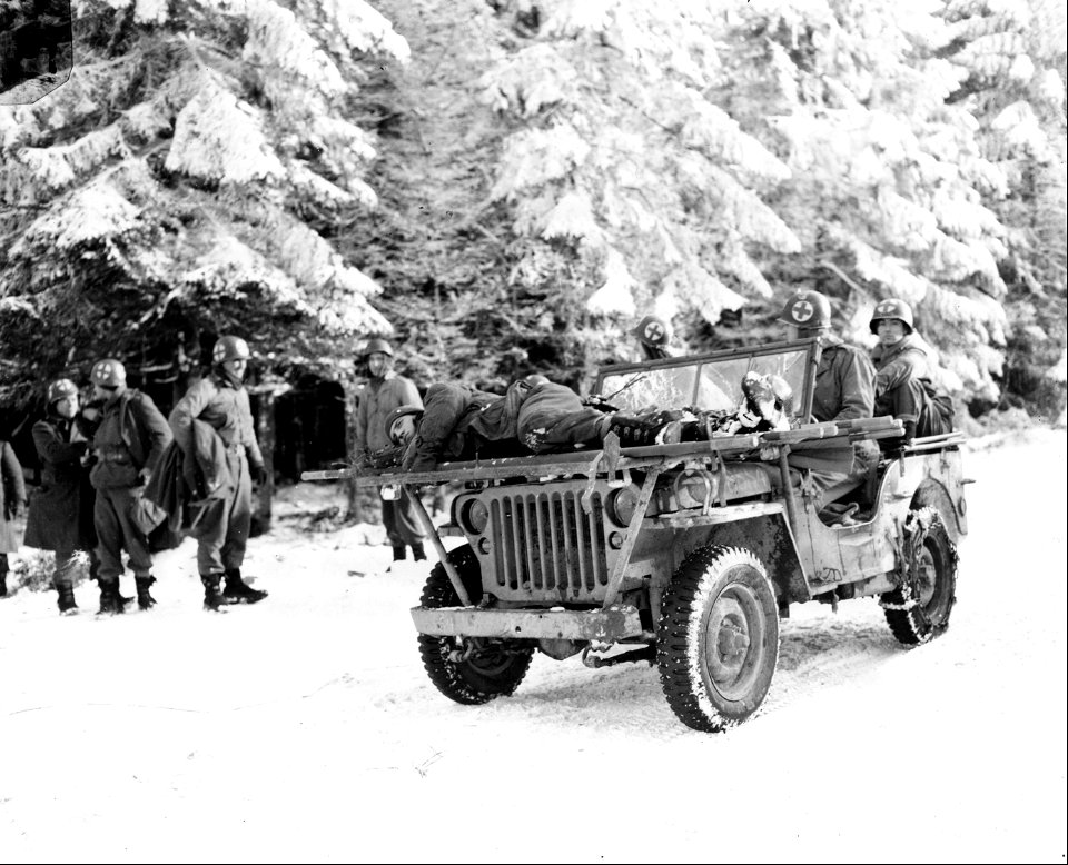 SC 199108 - Medics of the 84th Division bring casualties back on their jeep, near Samres, Belgium. 13 January, 1945. photo