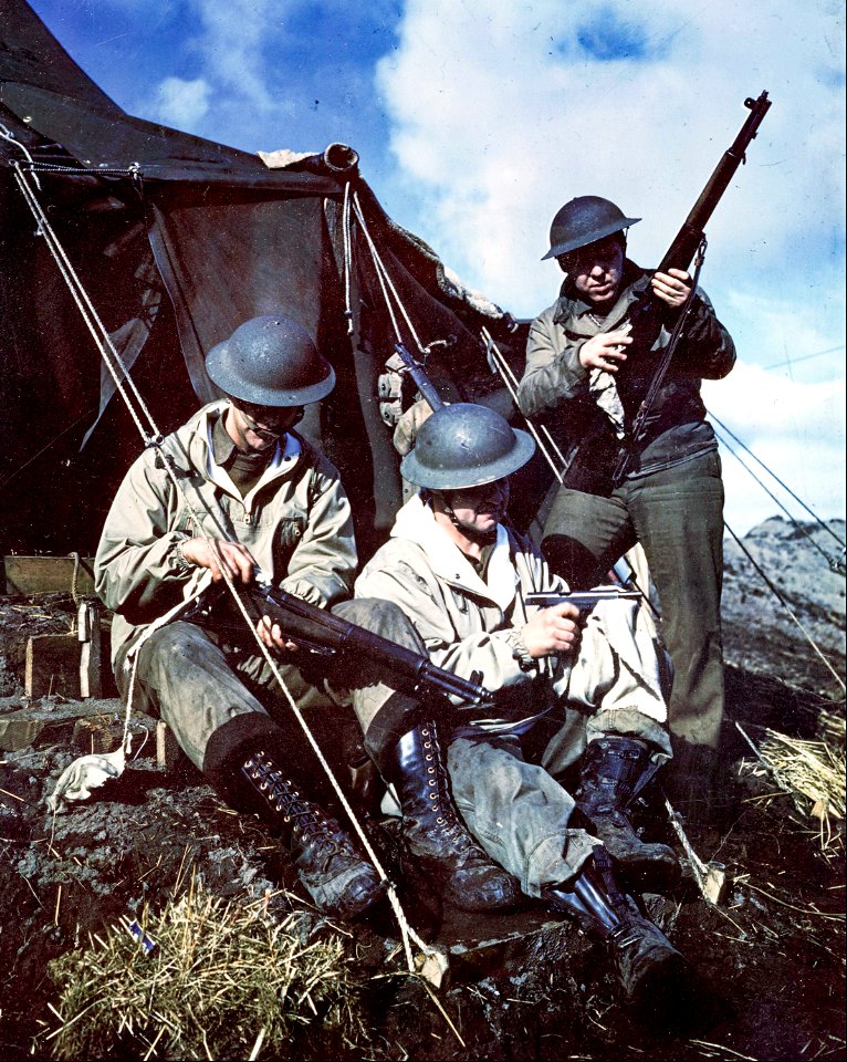 C-880 - Guns are kept clean and well-oiled on the island. Here three men sit in front of their tent and give their firearms a cleaning inspection. Aleutians.