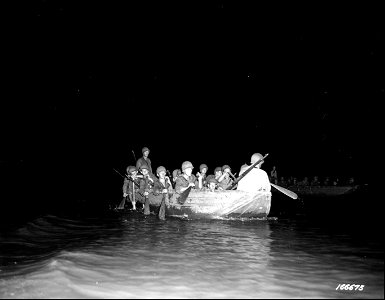 SC 166675 - Riflemen paddling on assault boat toward shore during a night problem. Rockhampton, Australia. 19 November, 1942. photo