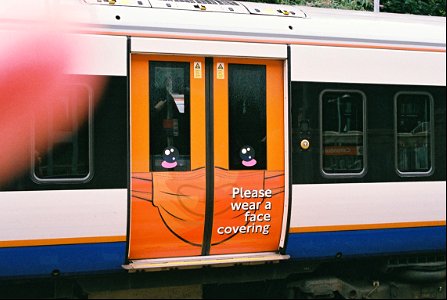 New face covering notice on doors of London Overground train photo
