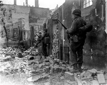 SC 270646 - Infantrymen of "G" Co., 7th Regiment, 3rd Infantry Division, 7th U.S. Army, take cover behind a wall as they move on to the Old City of Nuremburg. photo