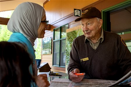 A volunteer helping a visitor photo