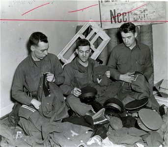 SC 337274 - Examining captured German uniforms in Gestapo building, are, left to right: photo