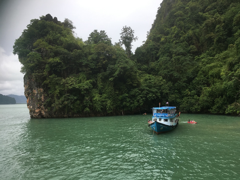Tourists kayaking through limestone cliffs in Phang-nga Bay