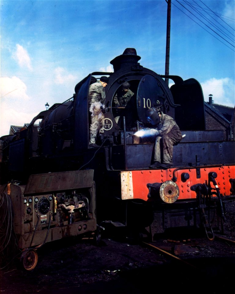 C-881 - These special railway repair men of an Engr. unit makes repairs on the Belgian and French locomotives that have been strafed and bombed by allied airmen.