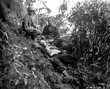 SC 151562 - Red Cross workers taking time out to give first aid to one of their wounded soldiers during maneuvers. Hawaii. photo