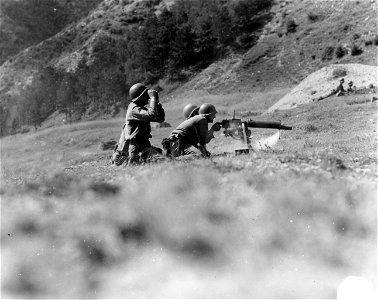 SC 329823 - Machine gun crew of 338th Inf., 85th Div., fires at German carrying demolitions. 19 September, 1944. photo